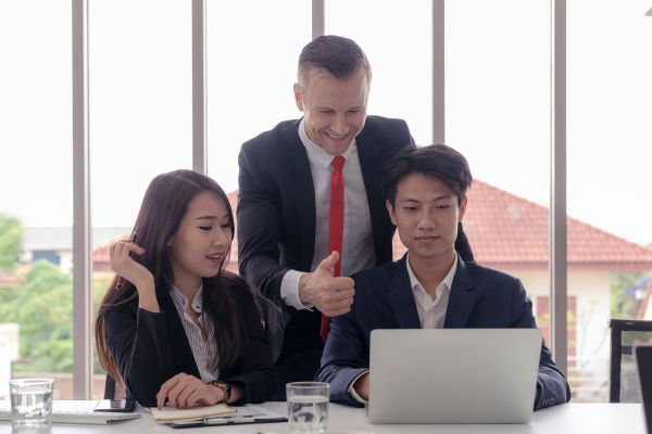 A manager approving work from two workers.