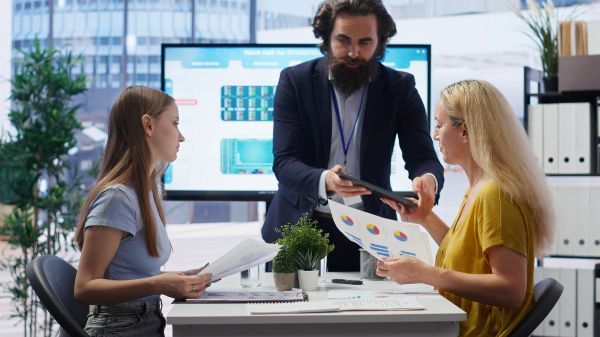 A man presenting to two women