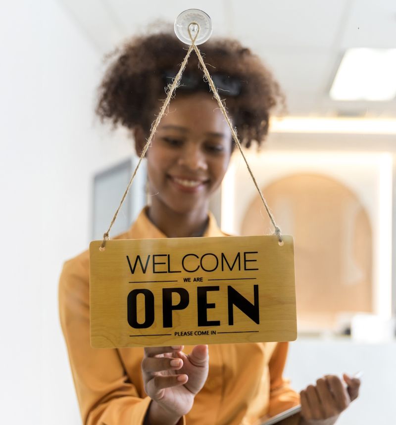 businesswoman flipping the open sign at a business