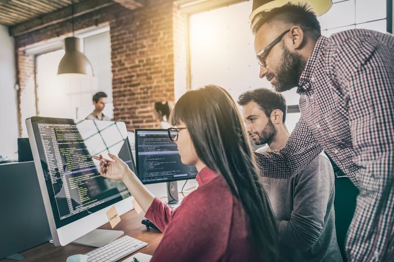 programmers looking at code on a computer together