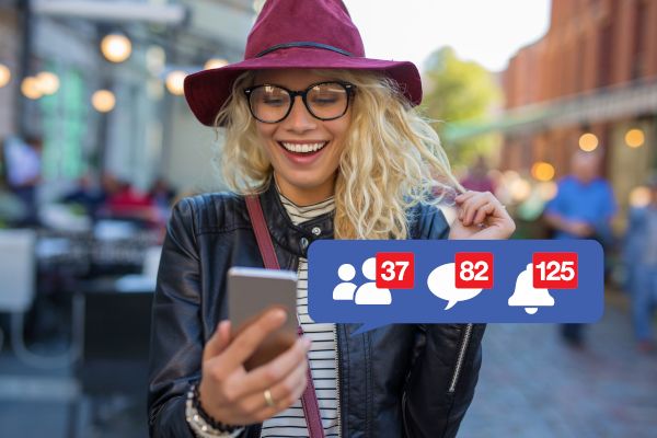 A happy woman browsing Facebook on her phone