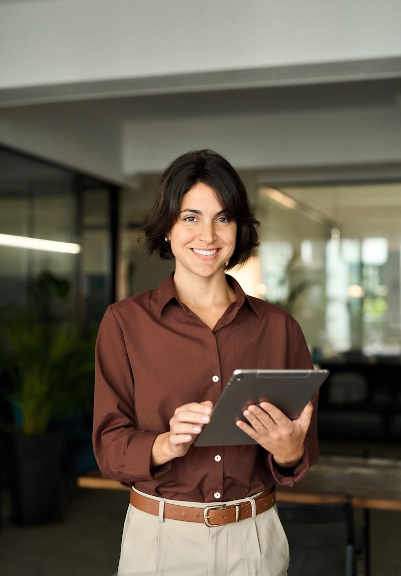 businesswoman smiling while holding a tablet device