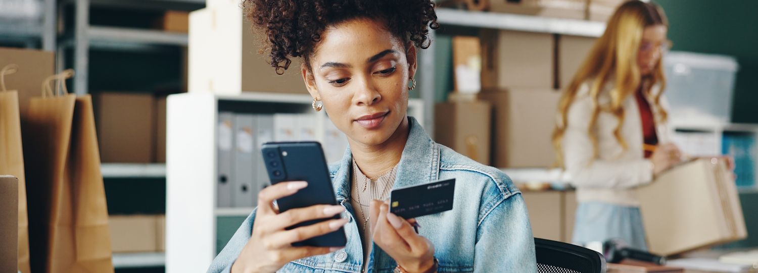 woman shopping on her phone with a credit card