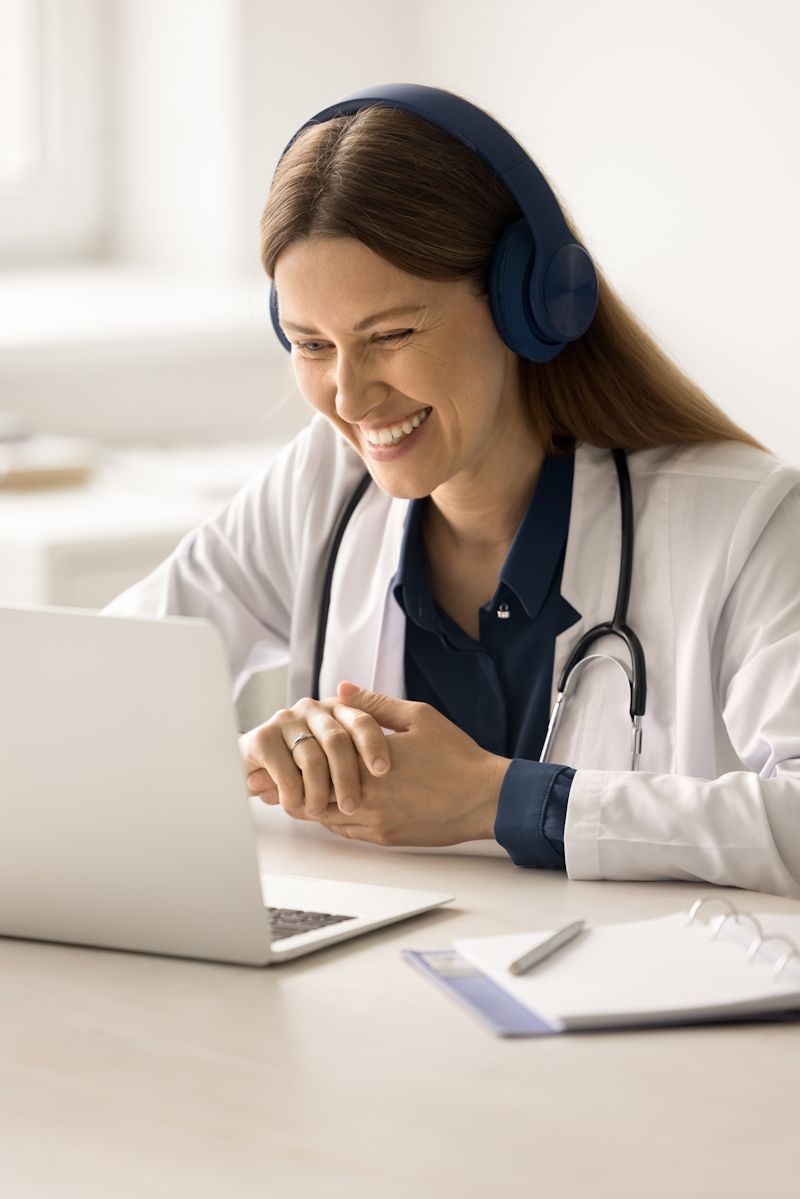 doctor wearing headphones at a laptop computer