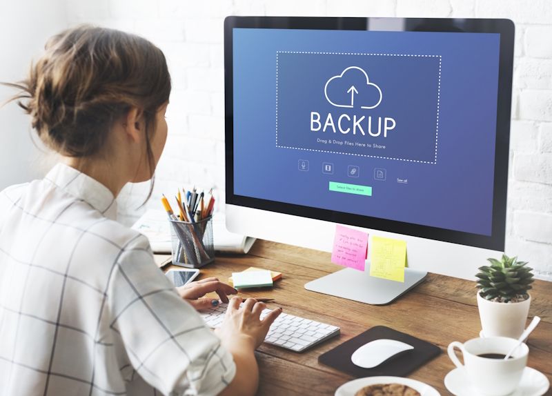 woman on a desktop computer accessing a cloud backup program