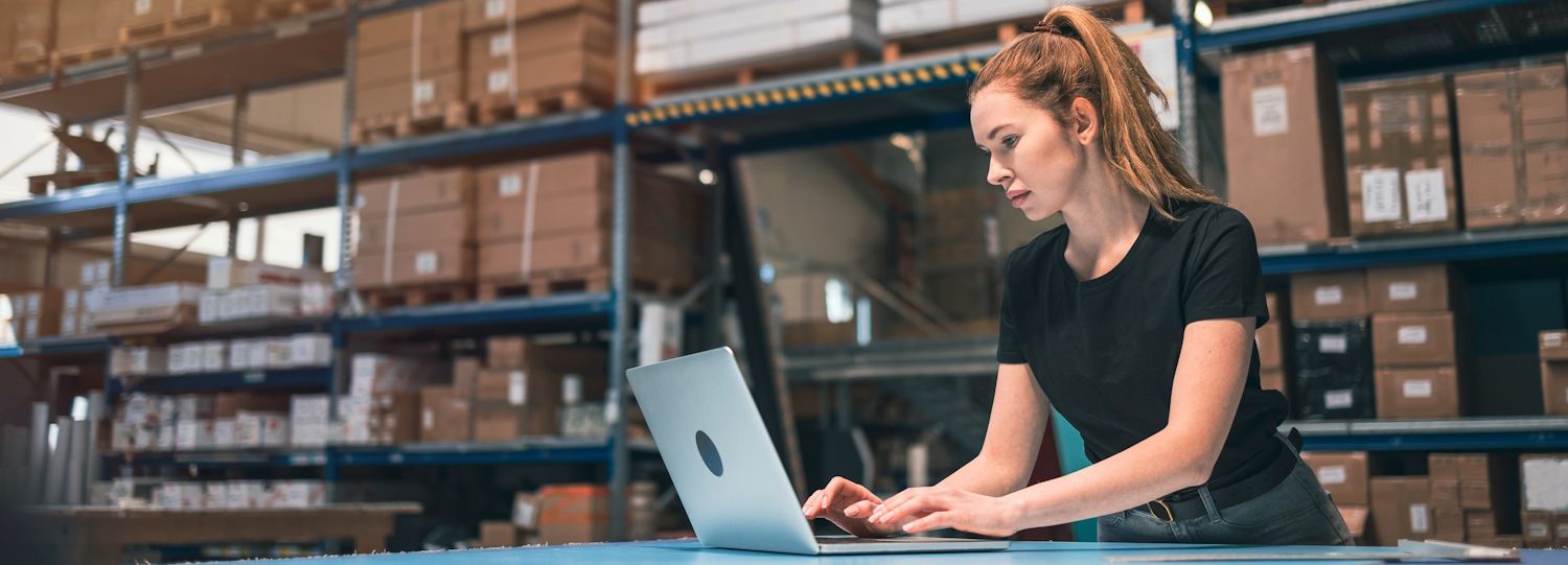 woman on a laptop in a warehouse