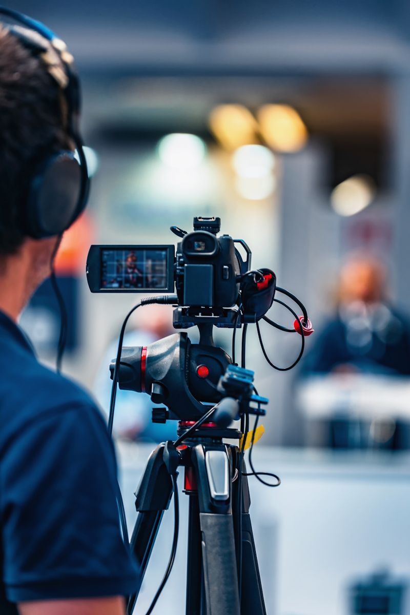 someone in headphones recording a video with a camera